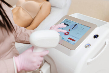 Therapist checking laser hair removal machine at aesthetic clinic. Woman beautician using laser epilation machine in beauty salon
