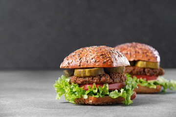 Two vegan burger with vegetables and pickle slices on dark background. Healthy food concept.