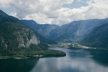 Naklejka na ściany i meble picturesque view of the village by the lake, surrounded by mountains from a bird's eye view