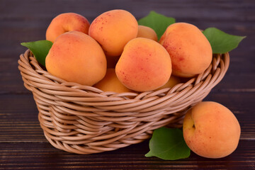 Fresh apricots in a basket on a wooden background.Close-up.
