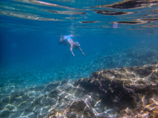 Fototapeta na wymiar Vista subacquea di una donna che fa snorkeling nel mare