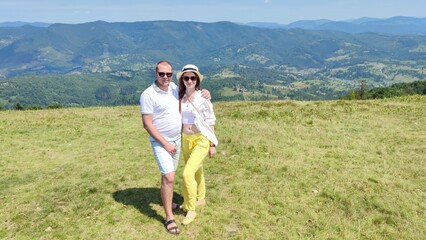 family couple on the background of mountains in summer. Carpathians Ukraine