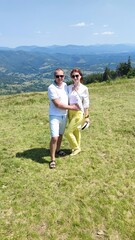 Naklejka premium family couple on the background of mountains in summer. Carpathians Ukraine
