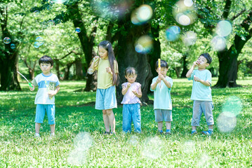 Obraz premium シャボン玉をして遊ぶ子供たち