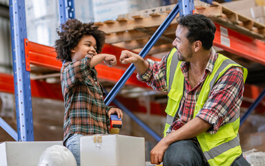 Little boy wearing safety hard hat deliver box or parcel to worker in factory for shipping to customer, smiling with happiness. Industry, Post Concept.