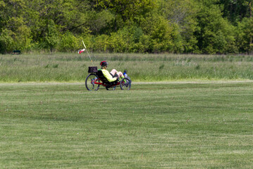 A Man Riding An Adult Tricycle On The Park Path In Spring