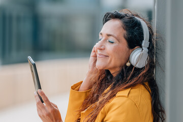 middle-aged woman with mobile phone and headphones