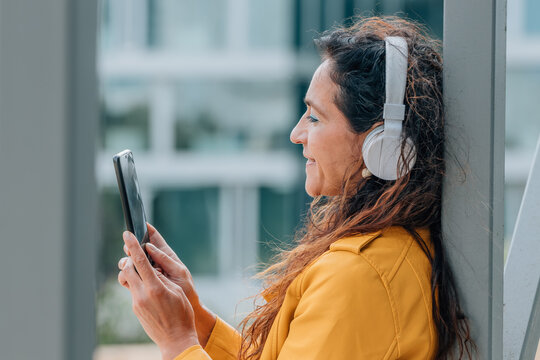 middle-aged woman with mobile phone and headphones