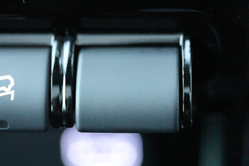 Extreme close up of a blank switch on a new car dashboard