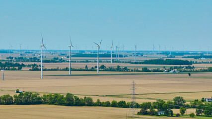 Wind farm aerial with power lines on summer day