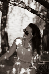 Portrait of a girl in sunglasses near the river in a city park in summer