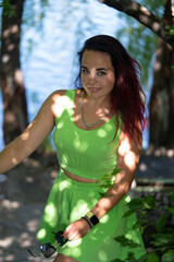 Portrait of a girl by the river in a city park in summer