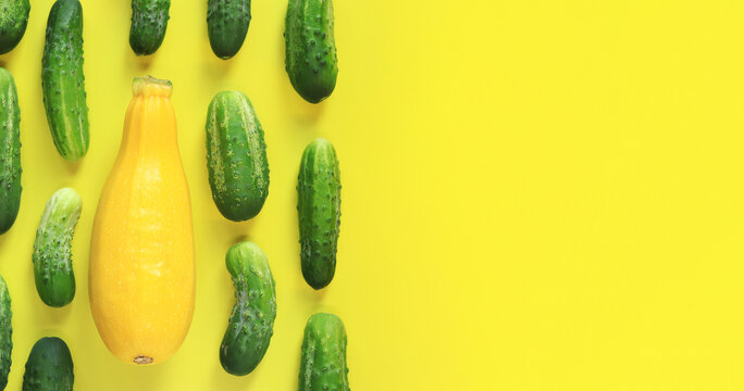 Freshly picked vegetables, zucchini and cucumbers on a yellow background, top view. Place for text