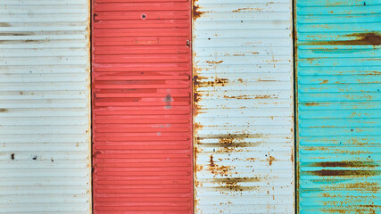Rusting white, red, and teal green metal containers from above, aerial, shipping containers
