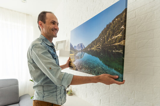 man holds canvas in the interior