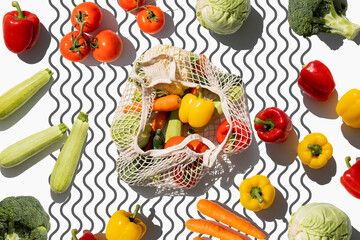 Fresh vegetables in bags on a light background. Top view, flat lay