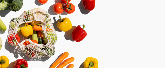 Fresh vegetables in a bag on a white background. Top view, flat lay. Banner