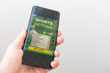 Shot of a man using a mobile phone shows a betting application with live results and updates with white background. Online betting concept.