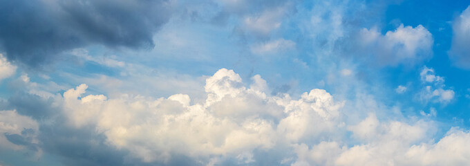 A dark cloud hangs over the white curly clouds