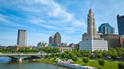 Fototapeta na wymiar Blue sky day with wispy white clouds over Columbus Ohio downtown with bridge and river