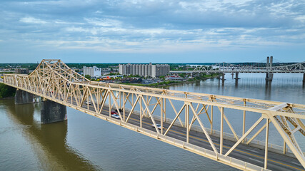 Aerial white gold truss bridge stretching across large river Ohio River