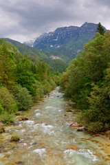 Fototapeta na wymiar Majestic turquoise Soca river in the green forest, Bovec, Slovenia, Europe. Beautiful rafting and kayaking place in Europe. Great recreation place and kayaking destination. 