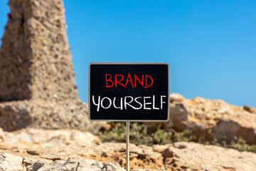 Brand yourself symbol. Concept words Brand yourself on beautiful black blackboard. Beautiful stone blue sky background. Business brand yourself concept. Copy space.