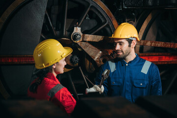 Fototapeta premium Industrial engineers inspect and perform maintenance on the machines at factory machines. Efficient Machinery Operation and Teamwork in the Manufacturing Industry