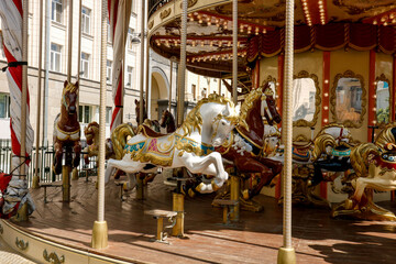 Fototapeta na wymiar spinning carousel with horses without riders