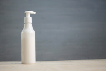 White pump bottle on a gray background. Empty space for an inscription.