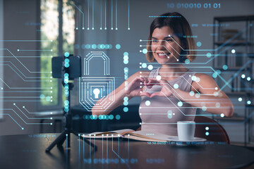 Happy woman is making video blog using smartphone on a tripod explaining with hands at office workplace. Concept of online stream, business education, conference call. Lock icons hologram