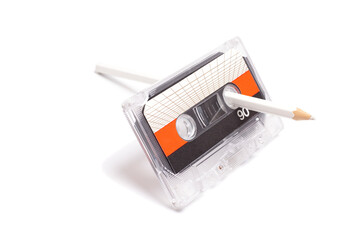 Audio cassette tape with pencil isolated on white background, vintage 80's music concept