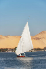 Cover image with copy space, a beautiful view of an Egyptian Felucca sail boat along the River Nile at Elephantine Island, A Nubian Village near Aswan, Egypt, Africa.