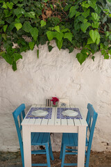 Pretty blue and white cafe restaurant table in a shaded side street in the popular tourist destination of Bodrum old town, Turkish Aegean coast of Turkey