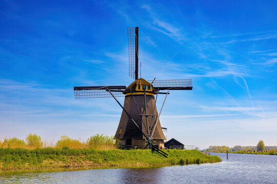 View of one of the huge windmills that occupies the entire image, sitting on the bank of the canal. Kinderdijk, Netherlands.