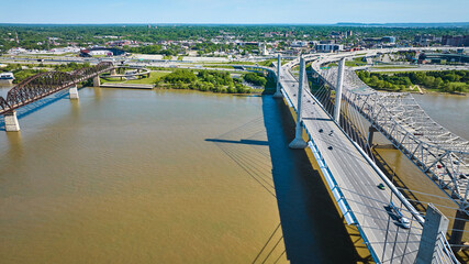 Ohio River aerial with suspension, truss, arch bridges leading to downtown city houses