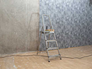 One room has been partially renovated. copy space. Pasting paper wallpaper on concrete walls.