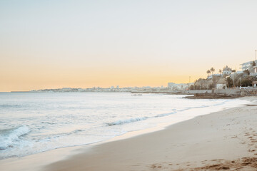 Summer landscape at beach at sunset, silky brown sand with waves rolling into the beach, banner, copy space
