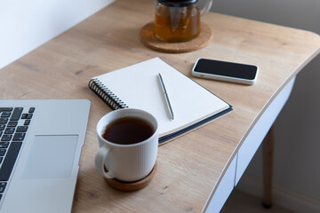 business composition with coffee. a cup of coffee on the background of a notepad and laptop on a wooden table.