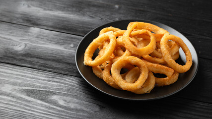 Crunchy Fried Battered onion rings on black plate