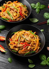 Stir fry chow mein noodles with pork and vegetable in black bowl. asian style food