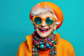 Happy senior woman in colorful neon outfit, funny sunglasses and extravagant style, laughing and smiling, trendy grandma posing in studio - obrazy, fototapety, plakaty