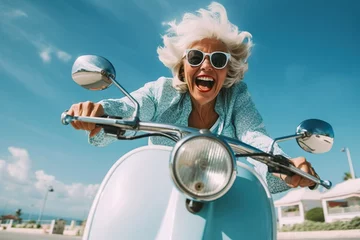 Selbstklebende Fototapeten Cheerful senior woman riding blue scooter in Italy, retired granny enjoying summer vacation, trendy bike road trip © iridescentstreet