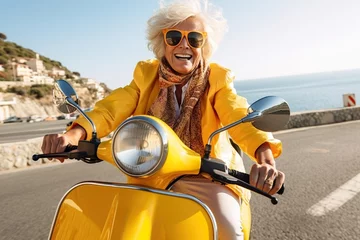 Foto auf Acrylglas Cheerful senior woman riding yellow scooter in Italy, retired granny enjoying summer vacation, trendy bike road trip © iridescentstreet