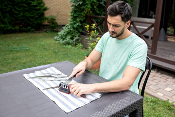Close-up photo of man sharpening knives with special knife sharpener