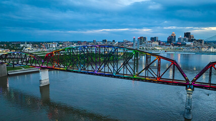Arch bridge aerial rainbow pride illuminated at night over Ohio River Louisville Kentucky