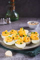 Eggs filled with a mixture of yolk, cheese, garlic and mayonnaise on a plate vertical view