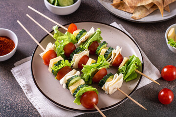 Fresh tomato, cucumber, cheese, tortilla and lettuce canape on a plate