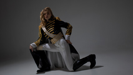 A glamorous blonde in a carnival uniform with epaulettes, posing with pretentious poses, a show host or a pop artist