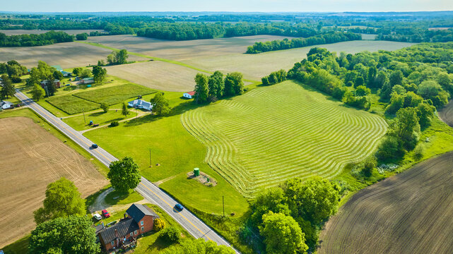 Country road with a mowed field a plowed field and many fallow fields aerial
